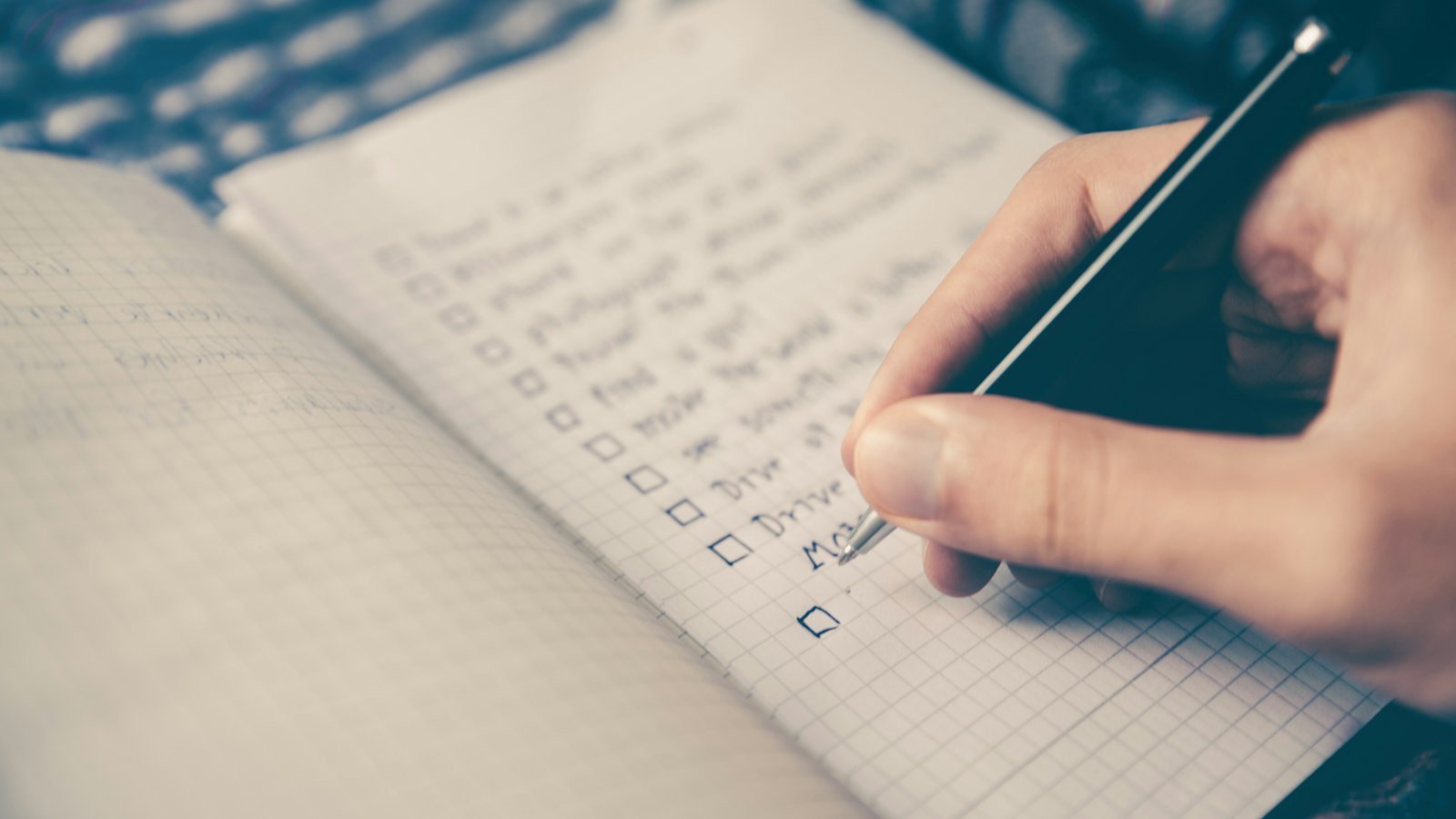 Person writing a list in a notebook